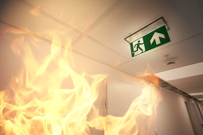 Certified technician inspecting and maintaining a commercial fire door during a fire safety training course